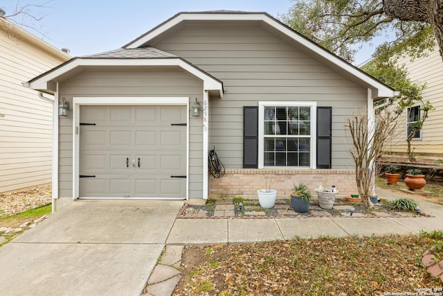 view of front of house featuring a garage, concrete driveway, and brick siding