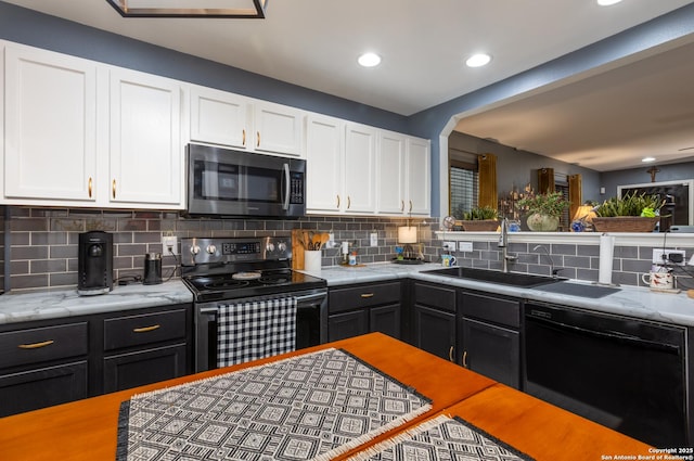 kitchen with electric stove, stainless steel microwave, white cabinetry, a sink, and dishwasher