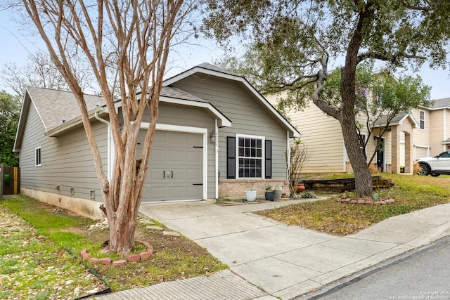 view of front of property featuring a garage, brick siding, driveway, and roof with shingles