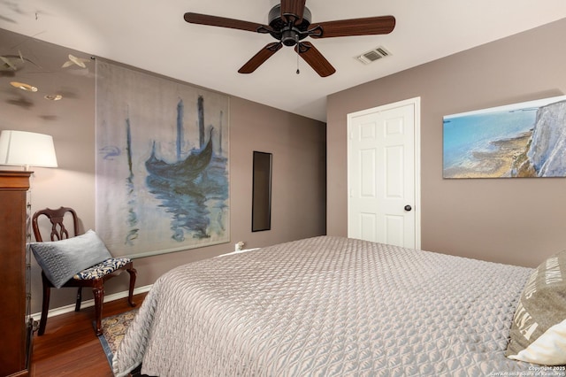 bedroom featuring ceiling fan, wood finished floors, visible vents, and baseboards