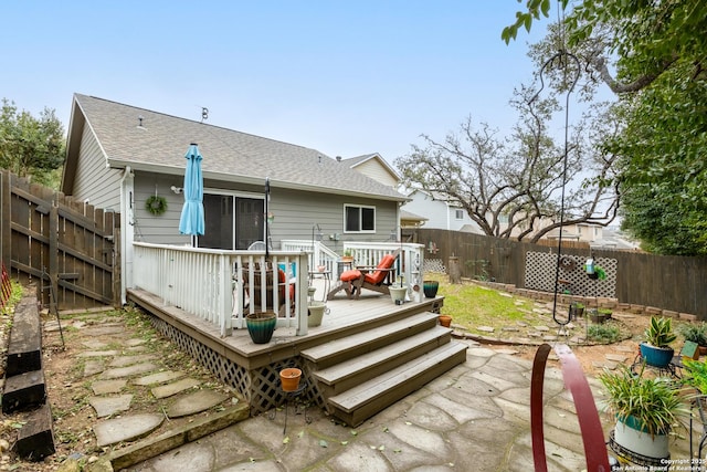 back of house featuring a fenced backyard, a wooden deck, and roof with shingles