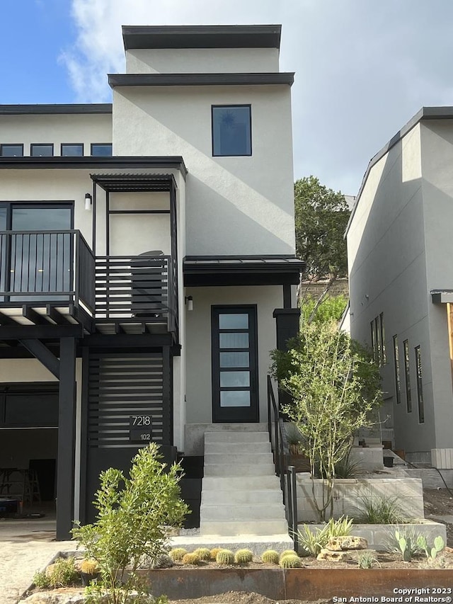 modern home with a balcony and stucco siding