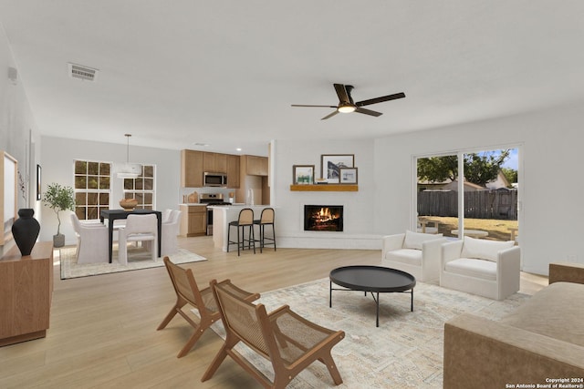 living room featuring visible vents, ceiling fan, light wood-style floors, a fireplace, and recessed lighting