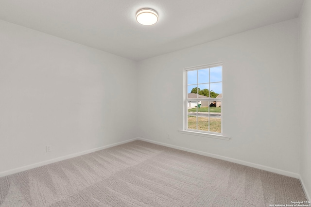 carpeted empty room with baseboards