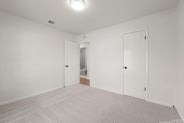 unfurnished bedroom featuring baseboards, visible vents, and carpet flooring