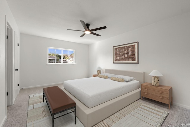 bedroom with baseboards, a ceiling fan, and light colored carpet