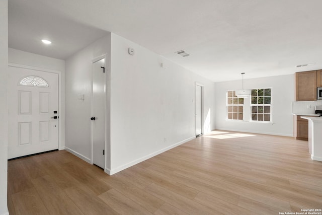 foyer featuring light wood-style floors, baseboards, and visible vents