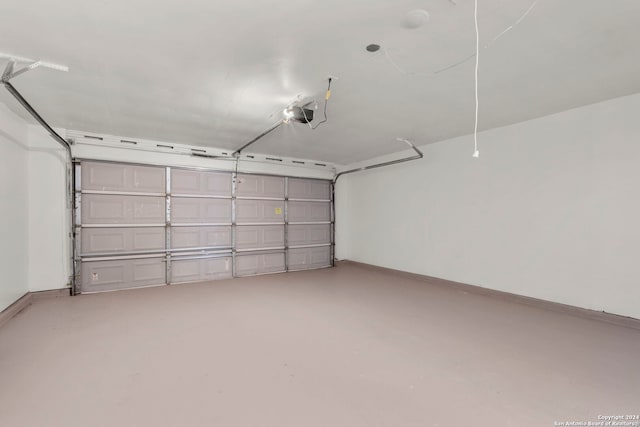 garage featuring a garage door opener and baseboards