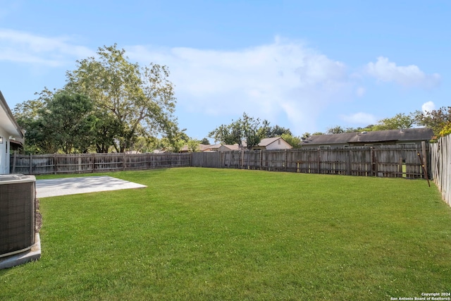 view of yard with central AC, a patio area, and a fenced backyard