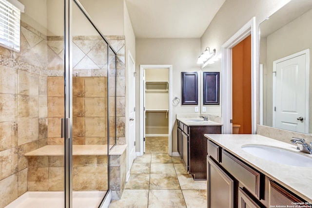 bathroom featuring a stall shower, two vanities, and a sink