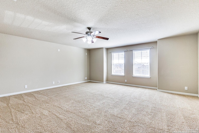 unfurnished room with light colored carpet, ceiling fan, a textured ceiling, and baseboards