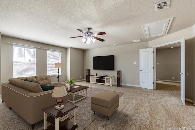 living room featuring carpet, visible vents, attic access, a ceiling fan, and baseboards