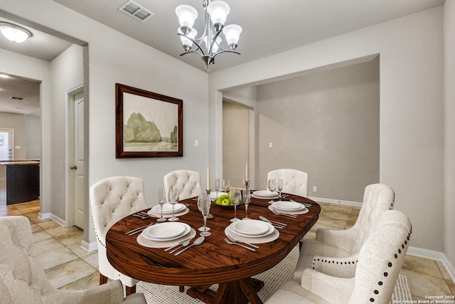 dining room featuring baseboards, visible vents, and an inviting chandelier