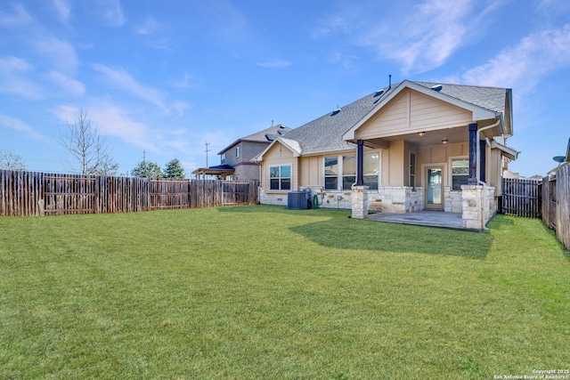 rear view of house featuring a patio, a fenced backyard, a shingled roof, a lawn, and board and batten siding