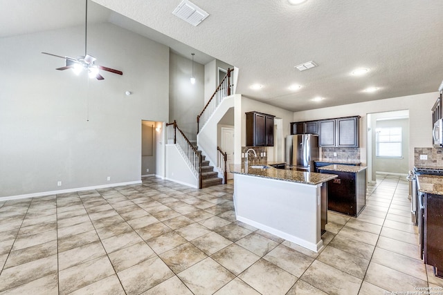 kitchen featuring dark brown cabinetry, visible vents, stone counters, and stainless steel appliances