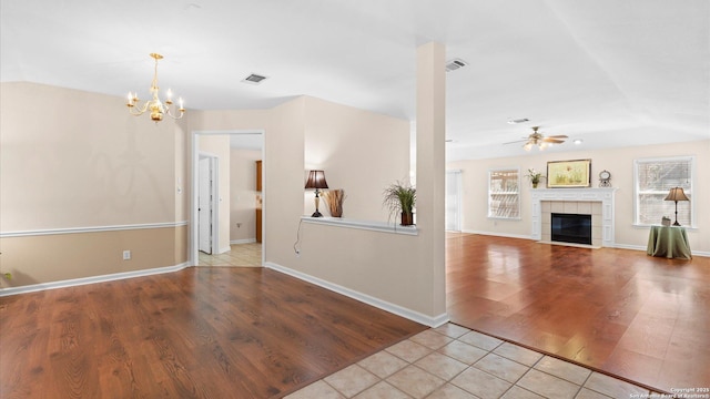 unfurnished living room featuring a healthy amount of sunlight, visible vents, and a tiled fireplace