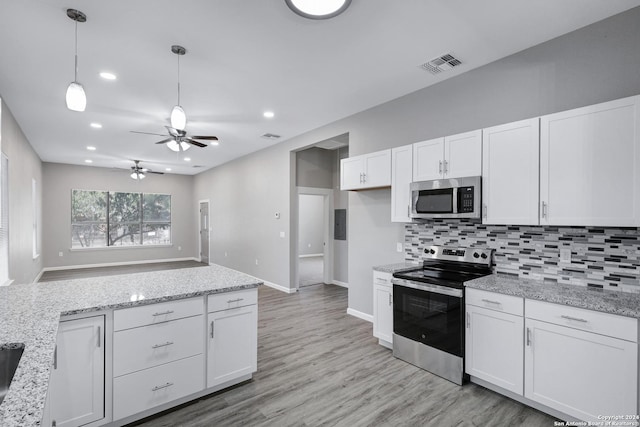 kitchen with visible vents, white cabinets, appliances with stainless steel finishes, decorative backsplash, and decorative light fixtures