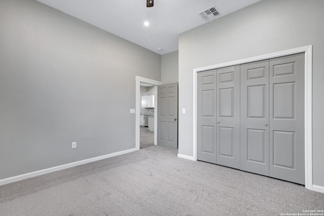 unfurnished bedroom featuring carpet floors, a closet, visible vents, a ceiling fan, and baseboards