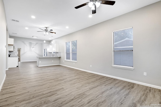 unfurnished living room featuring recessed lighting, visible vents, a ceiling fan, wood finished floors, and baseboards