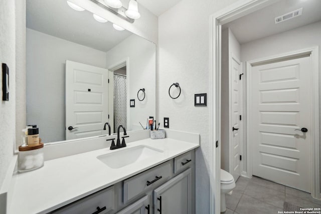 bathroom featuring tile patterned flooring, visible vents, vanity, and toilet