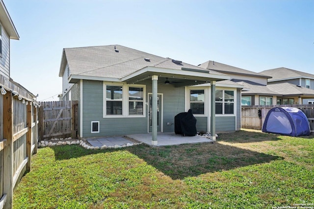 rear view of house with a fenced backyard, a lawn, a ceiling fan, and a patio