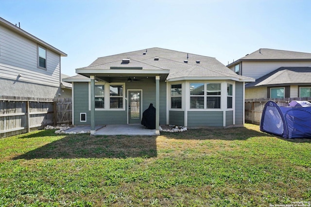 rear view of house featuring ceiling fan, a lawn, a patio area, and a fenced backyard