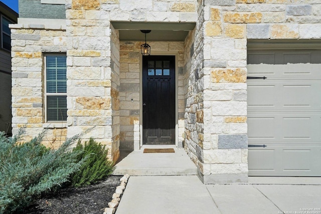 entrance to property with stone siding and an attached garage