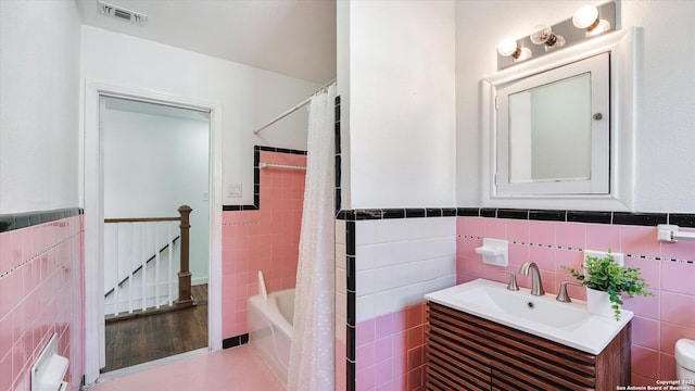 full bath featuring visible vents, tile walls, and vanity