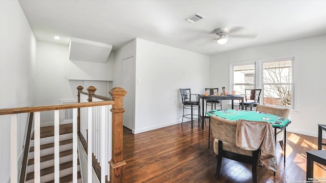 recreation room featuring a ceiling fan, visible vents, baseboards, and wood finished floors