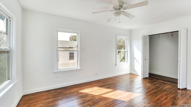 unfurnished bedroom featuring dark wood-type flooring, a closet, and baseboards