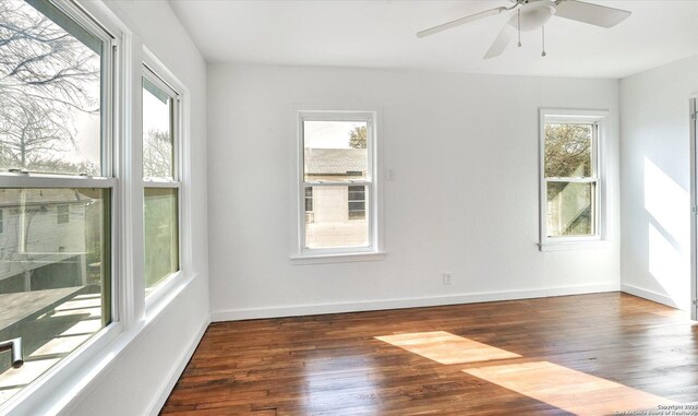 empty room with wood-type flooring, a ceiling fan, and baseboards