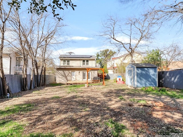 view of yard featuring an outbuilding, a fenced backyard, a deck, and a storage shed