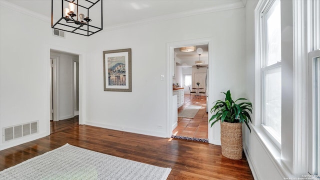 interior space featuring ornamental molding, visible vents, baseboards, and wood finished floors