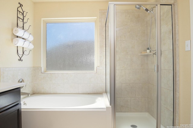 full bath with a shower stall, a bath, and vanity