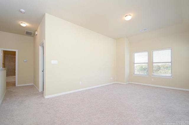 unfurnished room with light carpet, visible vents, and baseboards