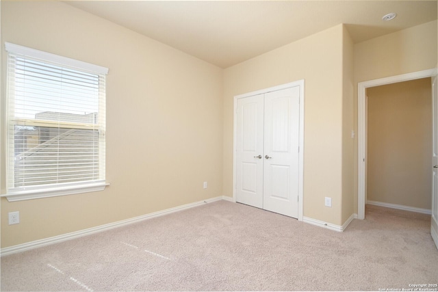 unfurnished bedroom with a closet, carpet, and baseboards