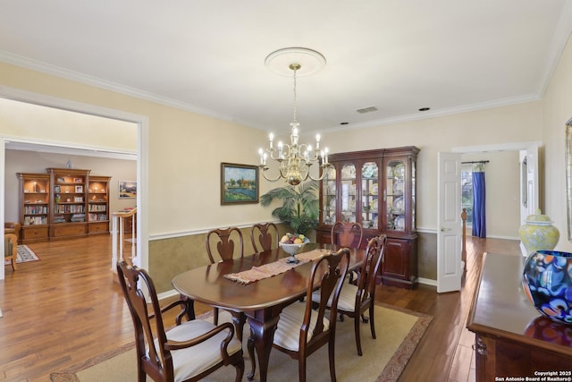 dining room with dark wood-style floors, a chandelier, visible vents, and ornamental molding