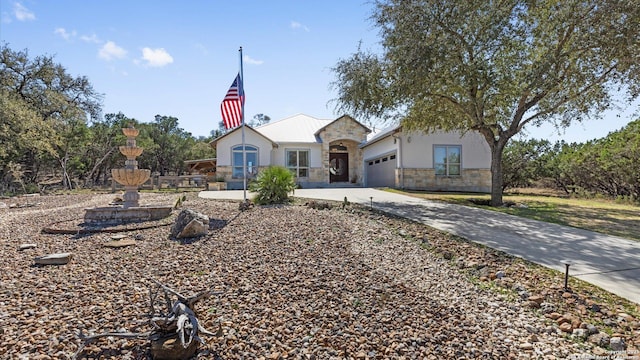 view of front of home featuring a garage, stone siding, concrete driveway, and stucco siding