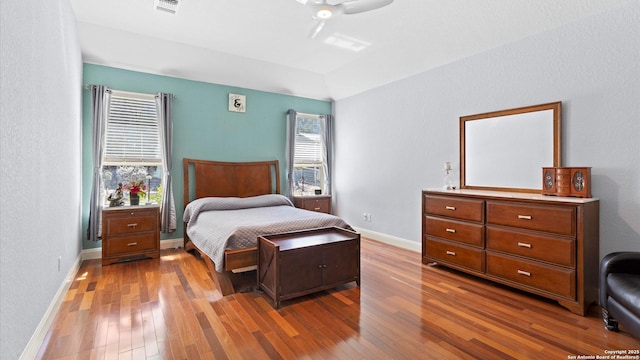 bedroom with wood-type flooring, a ceiling fan, and baseboards