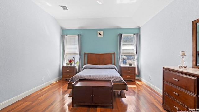 bedroom featuring visible vents, baseboards, and hardwood / wood-style flooring