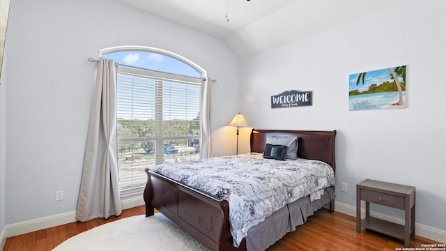 bedroom featuring vaulted ceiling, wood finished floors, and baseboards