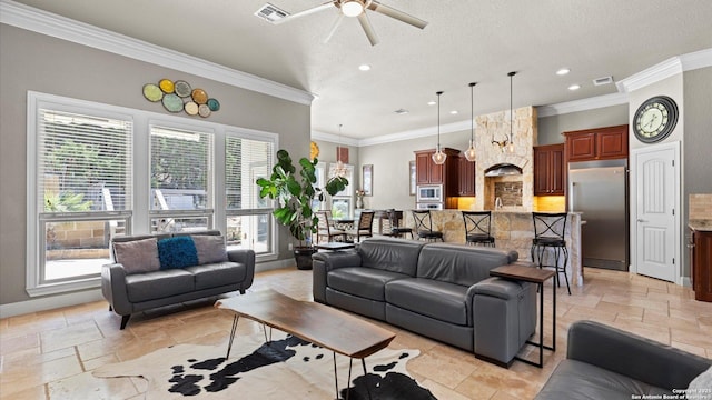 living room with ornamental molding, stone tile flooring, and visible vents