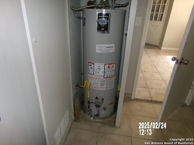 utility room with water heater and visible vents