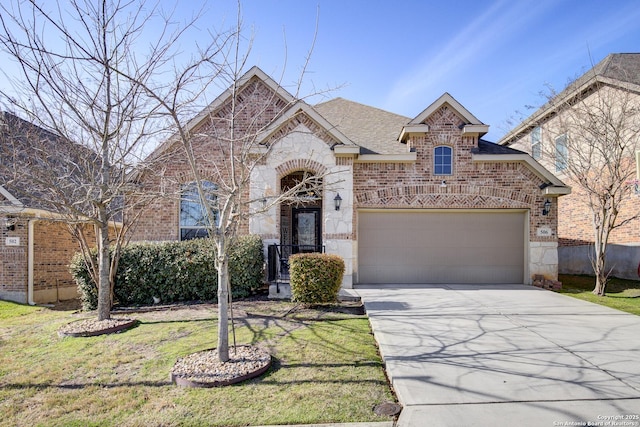 french provincial home with stone siding, brick siding, a front yard, and driveway