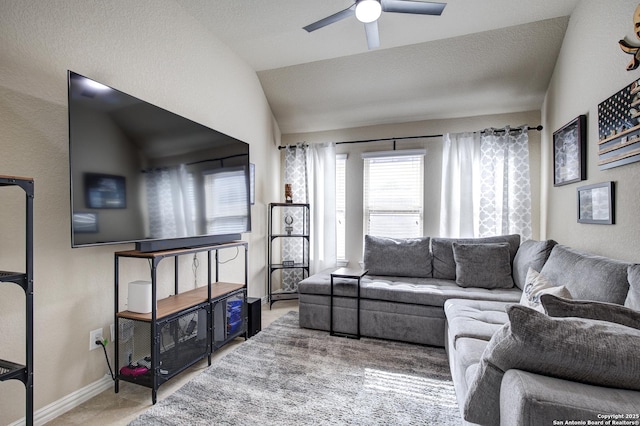 living room with baseboards, vaulted ceiling, and a ceiling fan