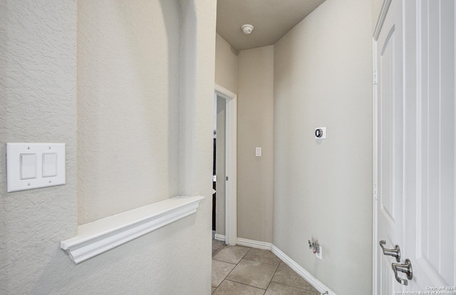 hallway featuring light tile patterned floors and baseboards