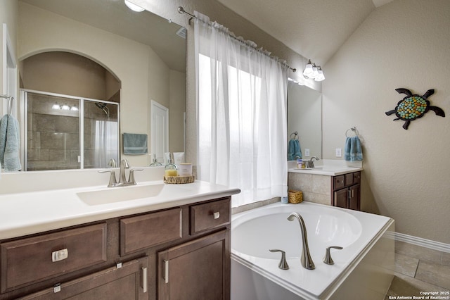 full bathroom with a stall shower, two vanities, tile patterned floors, a sink, and a bath