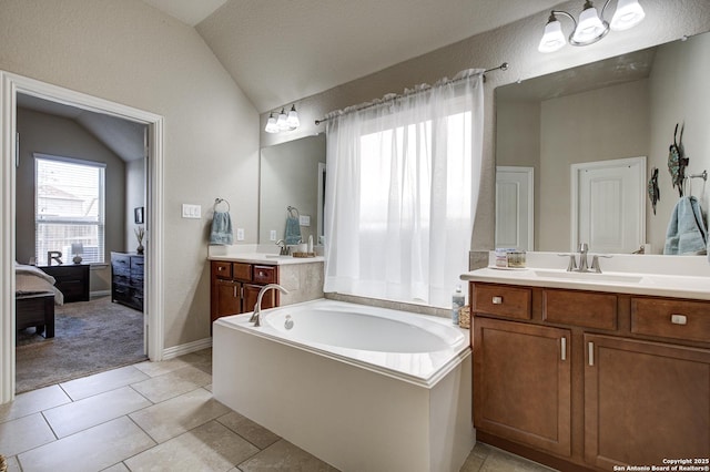 bathroom featuring tile patterned flooring, two vanities, a sink, vaulted ceiling, and a bath