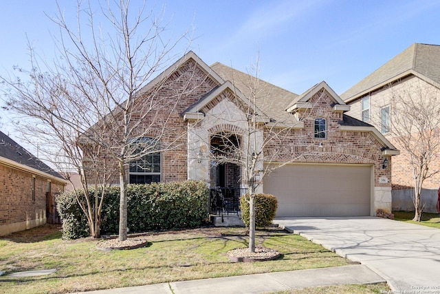 french country home featuring a garage, brick siding, a shingled roof, concrete driveway, and stone siding