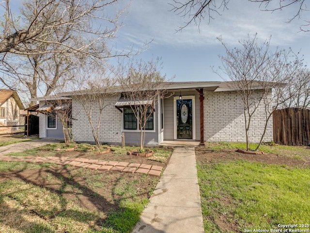 view of front of home featuring brick siding and fence